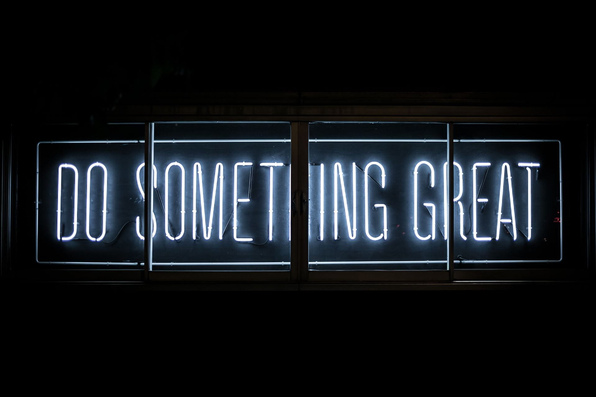 Neon white sign with words "Do Something Great"